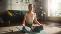 Athletic Young Female Exercising, Practising Meditation in the Morning in Her Bright Sunny Room at Royalty Free Stock Photo