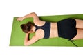 Athletic young girl lies face down on a yoga mat and stretches her arms forward in front of her Royalty Free Stock Photo