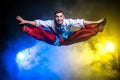 Athletic young handsome man in the Ukrainian national costume dance and jump on a dark background with smoke Royalty Free Stock Photo