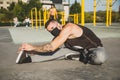 Young man with face mask stretching before calisthenics training