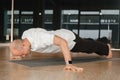 An athletic young man does exercises in the fitness room. A professional guy does yoga in the gym Royalty Free Stock Photo