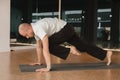 An athletic young man does exercises in the fitness room. A professional guy does yoga in the gym Royalty Free Stock Photo