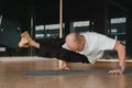 An athletic young man does exercises in the fitness room. A professional guy does yoga in the gym Royalty Free Stock Photo