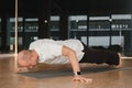 An athletic young man does exercises in the fitness room. A professional guy does yoga in the gym Royalty Free Stock Photo