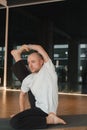 An athletic young man does exercises in the fitness room. A professional guy does yoga in the gym Royalty Free Stock Photo