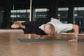 An athletic young man does exercises in the fitness room. A professional guy does yoga in the gym Royalty Free Stock Photo