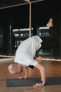 An athletic young man does exercises in the fitness room. A professional guy does yoga in the gym Royalty Free Stock Photo