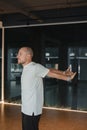 An athletic young man does exercises in the fitness room. A professional guy does yoga in the gym Royalty Free Stock Photo