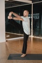 An athletic young man does exercises in the fitness room. A professional guy does yoga in the gym Royalty Free Stock Photo