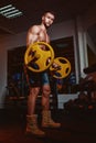 Athletic young man doing exercises with barbell in gym. Handsome muscular bodybuilder guy is working out. Royalty Free Stock Photo