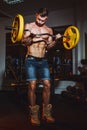 Athletic young man doing exercises with barbell in gym. Handsome muscular bodybuilder guy is working out. Royalty Free Stock Photo