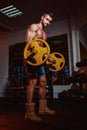 Athletic young man doing exercises with barbell in gym. Handsome muscular bodybuilder guy is working out. Royalty Free Stock Photo