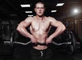 Athletic young man doing exercises with barbell in gym. Handsome muscular bodybuilder guy is working out. Royalty Free Stock Photo