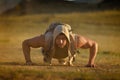 Athletic young man exercising outdoor on dusty field Royalty Free Stock Photo