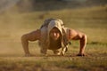 Athletic young man exercising outdoor on dusty field Royalty Free Stock Photo