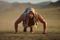 Athletic young man exercising outdoor on dusty field Royalty Free Stock Photo