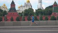 Athletic young man running against Moscow Kremlin