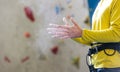 Athletic young man using magnesium for dry hands, dust flies from talcum powder, white chalk powder, indoor wall