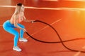 Athletic young blonde woman doing crossfit exercises with a rope. Royalty Free Stock Photo