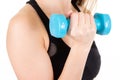 Athletic young woman doing fitness workout against white background Attractive fitness girl pumping up muscles with blue dumbbells Royalty Free Stock Photo