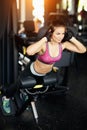 Athletic young woman doing hyperextension in the gym. Woman flexing back and abdominal muscles on bench. Royalty Free Stock Photo