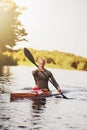Athletic young woman paddling on lake in summer Royalty Free Stock Photo