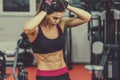 Athletic young woman showing muscles after workout in gym. Royalty Free Stock Photo