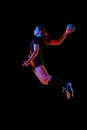 Athletic young woman, sportsman showing handball techniques, emphasizing skill and dedication against black background Royalty Free Stock Photo