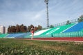 Athletic young woman in sportswear sprinting on running track stadium at sunset