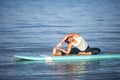 Athletic young woman in SUP Yoga practice side bend Pose in Ala