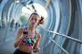 Athletic young woman using her mobile phone and listening to music for exercising
