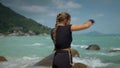 Athletically built female practicing the correct hook while standing on the big stone by the ocean