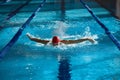 Athleticism in action. Young muscular man, swimmer in motion, action, training, swimming in pool indoors. Royalty Free Stock Photo