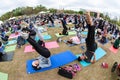 Dozens Of People Point Toes Upward Doing Yoga Pose Outdoors