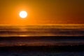 Majestic Sunrise Casting a Warm Orange Glow Over Misty Ocean Waves