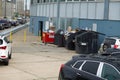 Multiple small dumpsters full of trash by the side of a building