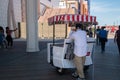 Man who pushes a famous rolling chair waits for a tourist to request a ride on the Atlantic City Boardwalk
