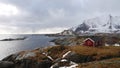 Atlantic Ocean and red rorbu holiday house on Toppoya on the Lofoten in Norway in winter