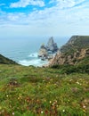 Atlantic ocean summer coast with granite boulder and sea cliffs, sandy beach and flowers in front. View from Cape Roca Cabo da Royalty Free Stock Photo
