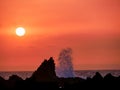 Atlantic Sunset with waves crashing onto cliffs