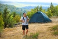 Atlethic man with backpack and tent standing on nature background Royalty Free Stock Photo