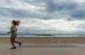 Atlethic woman running in front of the beach