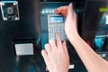 ATM and banking operations. The woman, covering his hand, enters the password from the Bank card. Close up