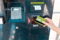 ATM and banking operations. A woman leans a Bank card in the reader at the ATM