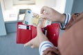 Unrecognizable female holding in hands wallet with euro money near the ATM. Withdrawing cash to pay for services, a loan Royalty Free Stock Photo