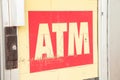atm sign capital letters writing text on store door in beige white writing. p