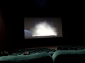 Atmosphere in theatre with rows of seats, big sreen and people watching movie Royalty Free Stock Photo