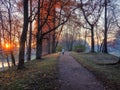 Atmospheric autumn morning landscape with sunrise and silhouette of a woman on a winding road in the park Royalty Free Stock Photo
