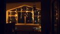 Atmospheric Christmas window decorated with yellow twinkle lights