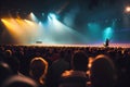An atmospheric image of a music concert audience, featuring silhouettes of fans and misty stage lights in the background,